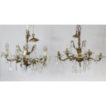 A pair of ornate brass five-branch ceiling light fittings, hung with cut-glass prism drops, 18” wide