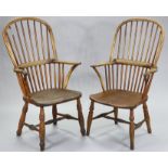 A near pair of 19th century ash & elm Windsor armchairs, with hooped spindle backs, curved arms, &