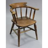 A 19th century ash & elm Windsor-type captain’s chair, with curved back & scroll arms on turned spi