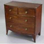 A late 18th/early 19th century mahogany bow-front chest, fitted two short & two long drawers with