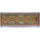 A Choli kelim runner of ivory ground, with multi-coloured repeating geometric design & central row