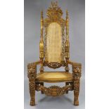 An Indonesian hardwood master’s chair, with all-over profusely carved decoration, having tall