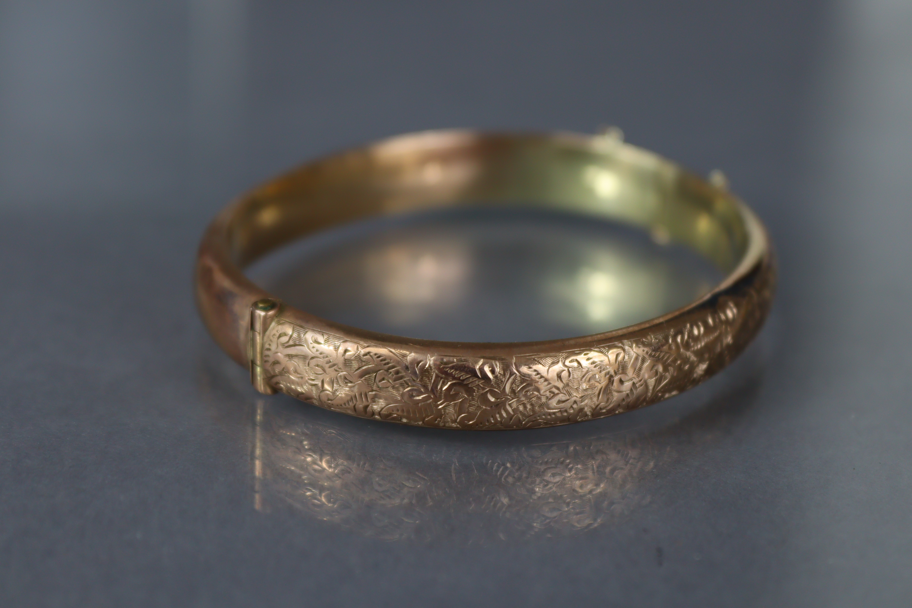 A 9ct. gold stiff hinged bangle with engraved decoration to one half; Chester hallmarks for 1912. ( - Image 3 of 4