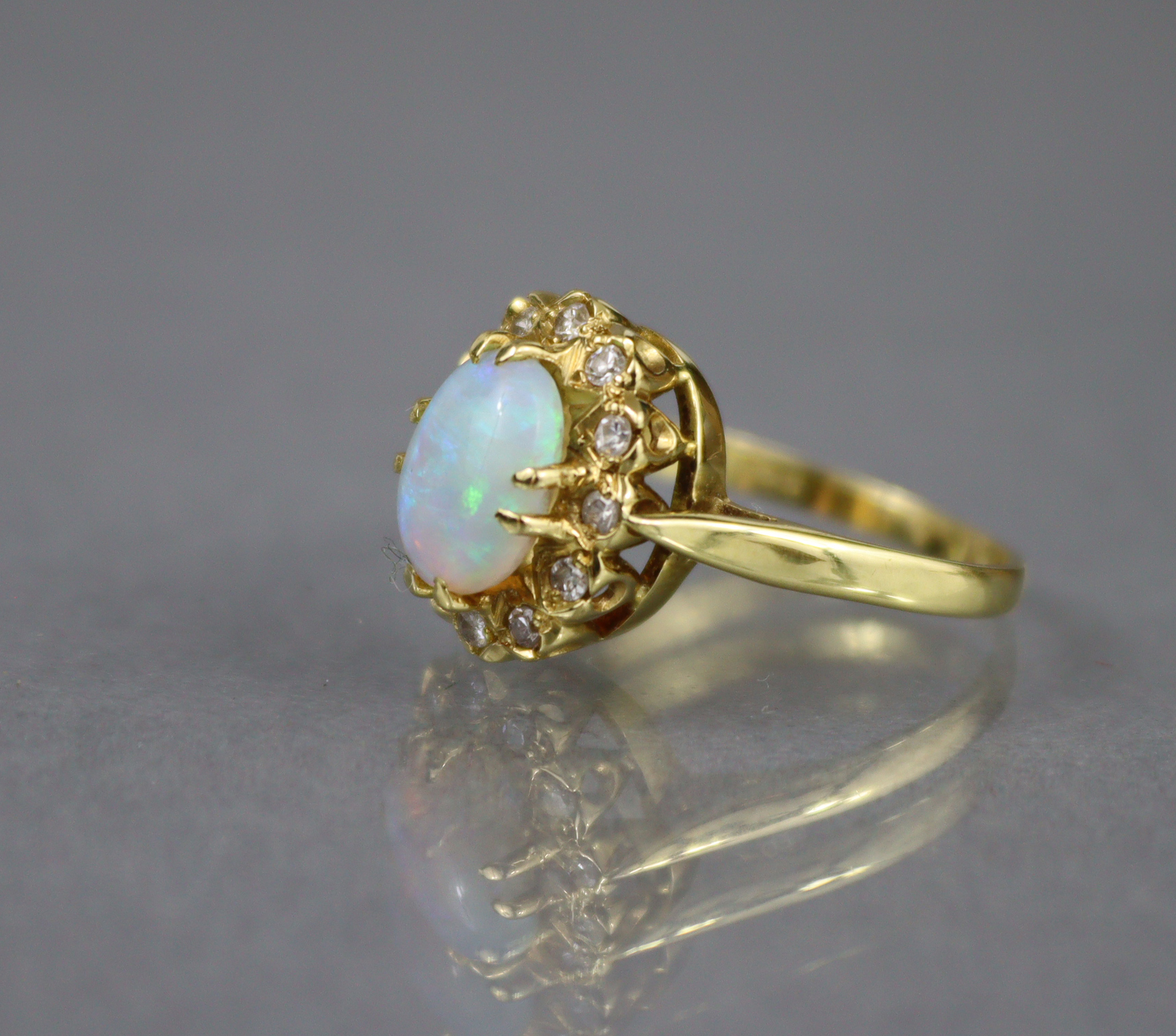 An 18ct. gold ring set oval opal within a border of small diamonds, Birmingham hallmarks for 1875; - Image 3 of 6