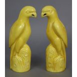 A pair of Chinese porcelain monochrome yellow models of parrots, each on rocky base; 9¼” high.