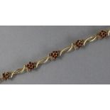 A 9ct. gold flexible bracelet of crossed arc links with cluster of small topaz at intervals, 7¼”