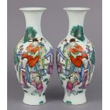 A pair of Chinese porcelain baluster vases, each decorated in famille rose enamels with scholars &