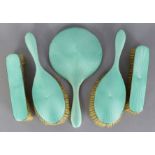 A George V silver & pale green guilloche enamel dressing table set comprising a hand mirror, pair of
