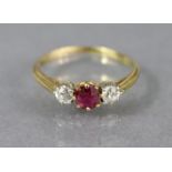 A gold ring set round-cut ruby flanked by a small diamond either side, hallmarks rubbed; Size: L/