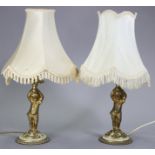 A pair of 19th century gilt brass table lamps, each with “cherub” support on a round base inset