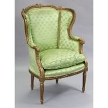 A Louis XVI-style giltwood & gesso frame armchair with rounded wing-back, padded arms & squab