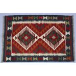 A Maimana kilim rug of ivory ground, with central repeating lozenge-shaped design in red, orange,