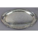 A George V silver oval two-handled tray with anthemions to the shaped moulded rim, 22” x 15”;