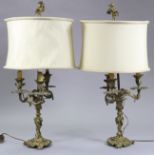 A pair of 19th century gilt brass three-branch table lamps with tall shade supports, scrolling