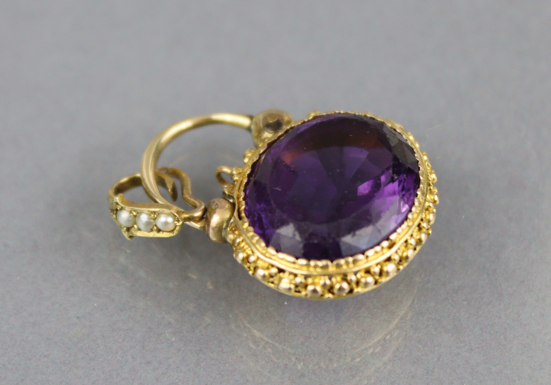 A Victorian amethyst pendant, the oval stone measuring approx. 18mm x 15mm x 9mm, set within a - Image 2 of 3