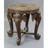 An eastern hardwood occasion table with circular top, on four elephant head supports joined by