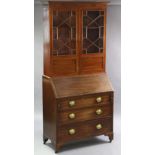 A Georgian mahogany bureau bookcase with moulded cornice above two adjustable shelves enclosed by