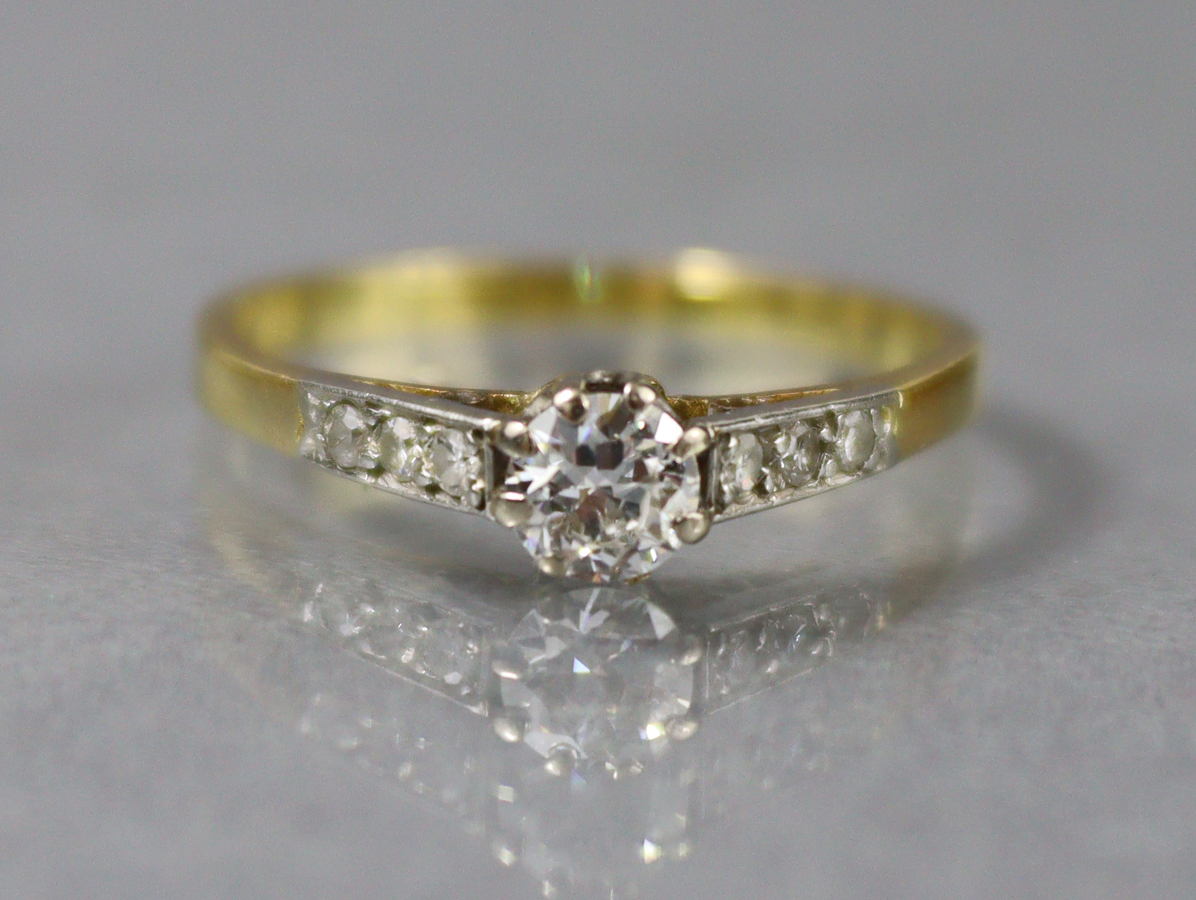 A diamond ring, the round-cut centre stone approx. 0.2 carat, a row of three smaller diamonds to