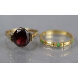 A yellow metal ring set oval garnet, the shank marked “9ct”, Size: L; weight 2.6gm; & an un-marked