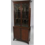 A George III-style mahogany bookcase, fitted two adjustable shelves enclosed by pair of glazed