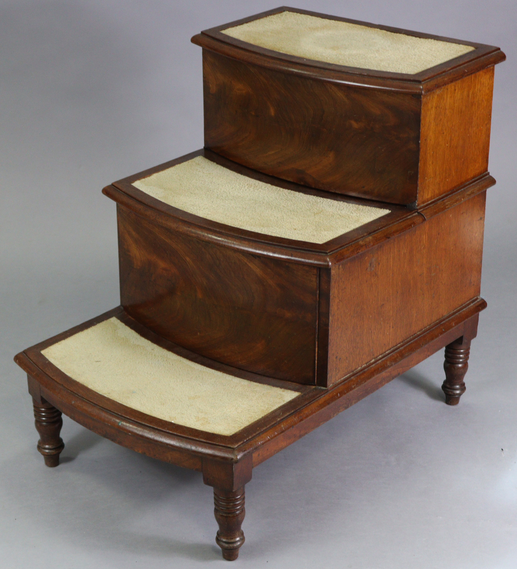 A Victorian mahogany steps commode, with bow-fronts, hinged lift-lids, on short turned