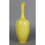 A CHINESE PORCELAIN MONOCHROME YELLOW VASE of slender ovoid form, with flared rim to the tall narrow