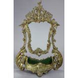 A Victorian gilt metal swing toilet glass, with heavily stylised frame & shaped mirror pane with