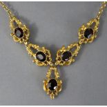 A 9ct. gold & garnet necklace, the five oval-cut garnets set to cast & pierced C-scroll links,