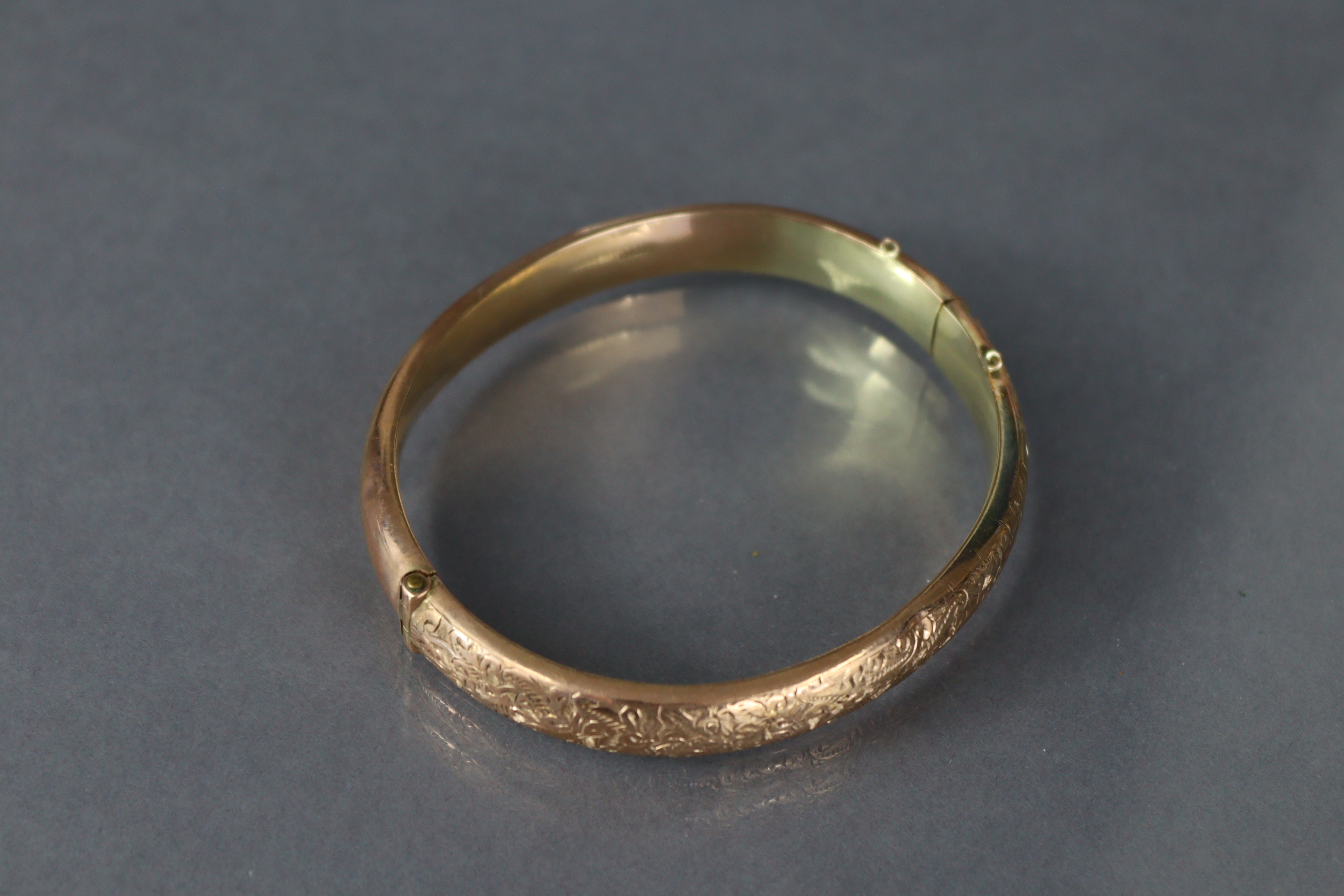 A 9ct. gold stiff hinged bangle with engraved decoration to one half; Chester hallmarks for 1912. ( - Image 4 of 4