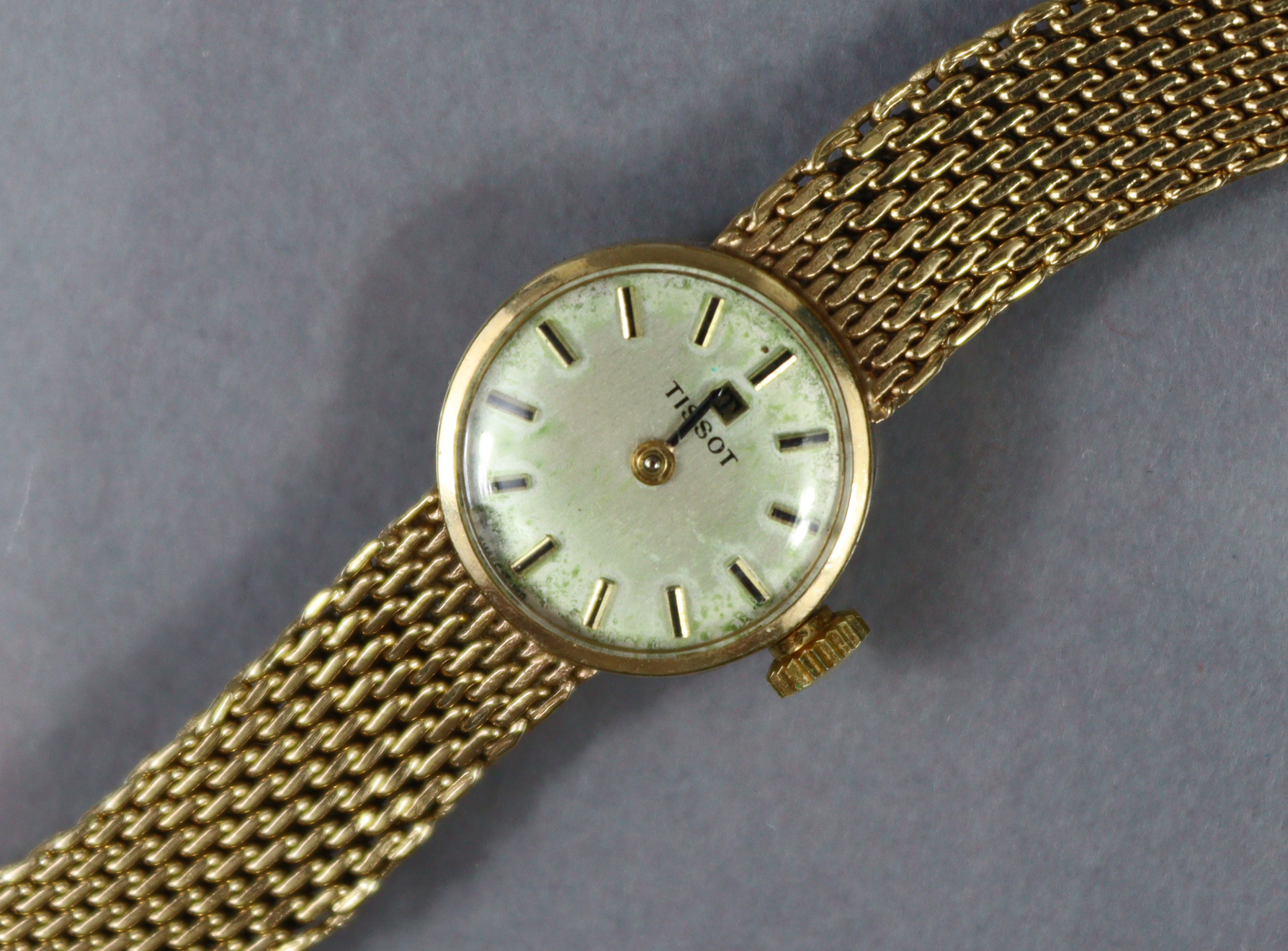 A Tissot 9ct. gold ladies’ bracelet watch with baton numerals to the small circular silvered dial,