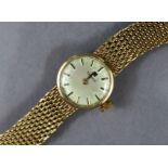 A Tissot 9ct. gold ladies’ bracelet watch with baton numerals to the small circular silvered dial,