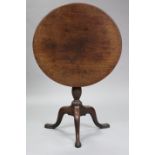 A George III mahogany tripod table with circular tilt-top on birdcage support & baluster turned