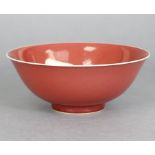 A Chinese porcelain copper-red glazed bowl, with slightly flared rim & raised on short foot, the