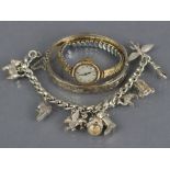 A 9ct. gold ladies’ wristwatch with gilt-metal expanding bracelet; a silver stiff hinged bangle with