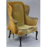 An 18th century wing-back armchair, with curved scroll arms, padded back & seat, on slender