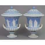 A pair of 19th century Wedgwood blue jasperware campana-shaped vases & covers, decorated with