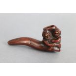 A Japanese pottery erotic smoking pipe, an embracing couple forming the bowl; 3¾” long.