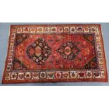 A Turkoman rug of crimson ground, with central lozenge motif, with figures & animals to the