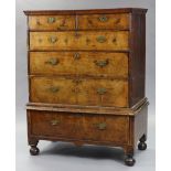 A Queen Anne figured walnut chest-on-stand, with moulded cornice, fitted two short & four long