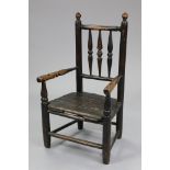 A 19th century provincial oak child’s chair with turned rail back, open arms, hard seat, & on