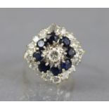 A diamond & sapphire cluster ring, the centre diamond approx. 0.2 carat set within a border of small