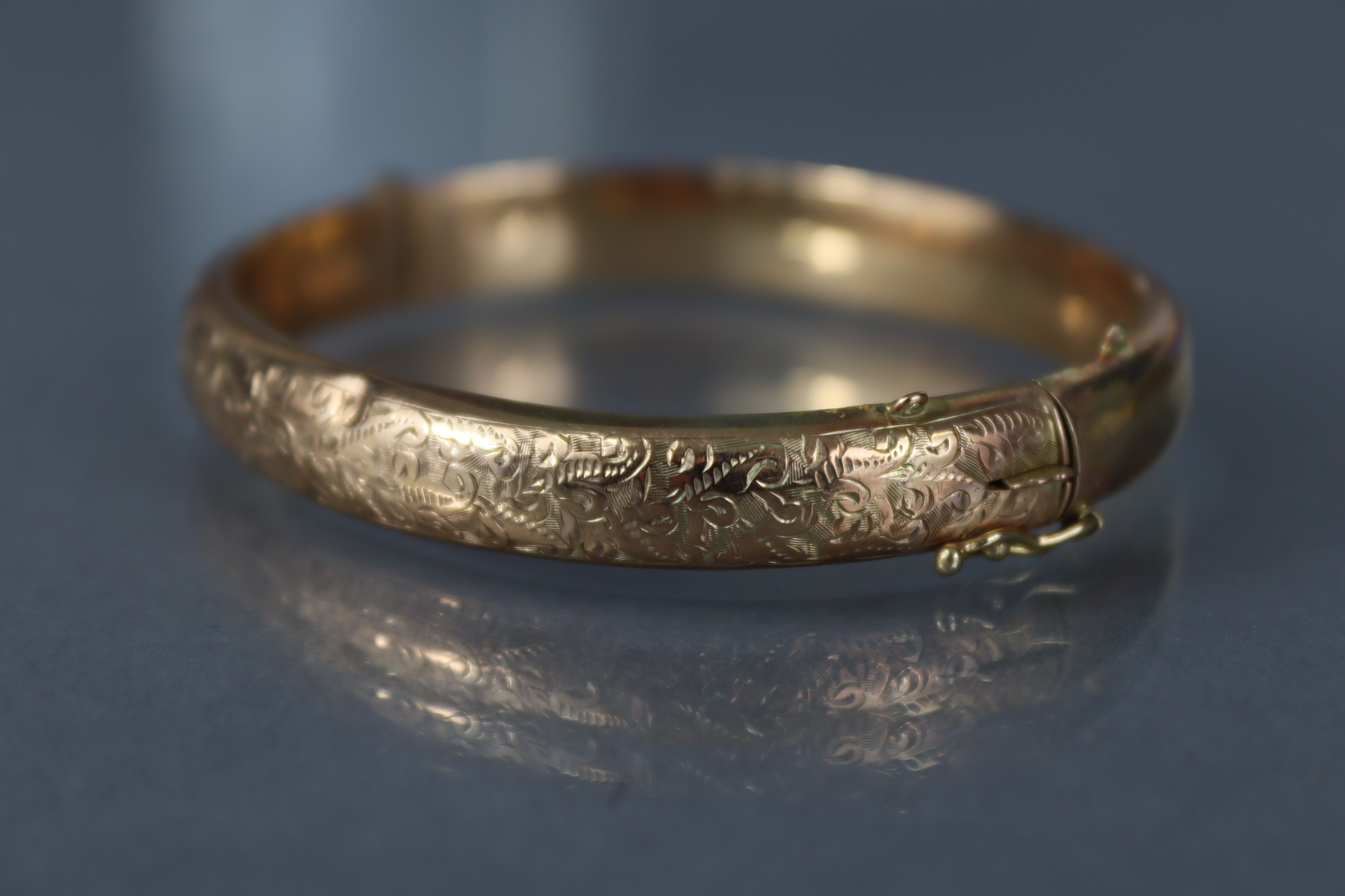 A 9ct. gold stiff hinged bangle with engraved decoration to one half; Chester hallmarks for 1912. ( - Image 2 of 4
