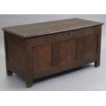 A late 17th century joined oak coffer with carved triple-panel front, hinged lift-lid, & on short