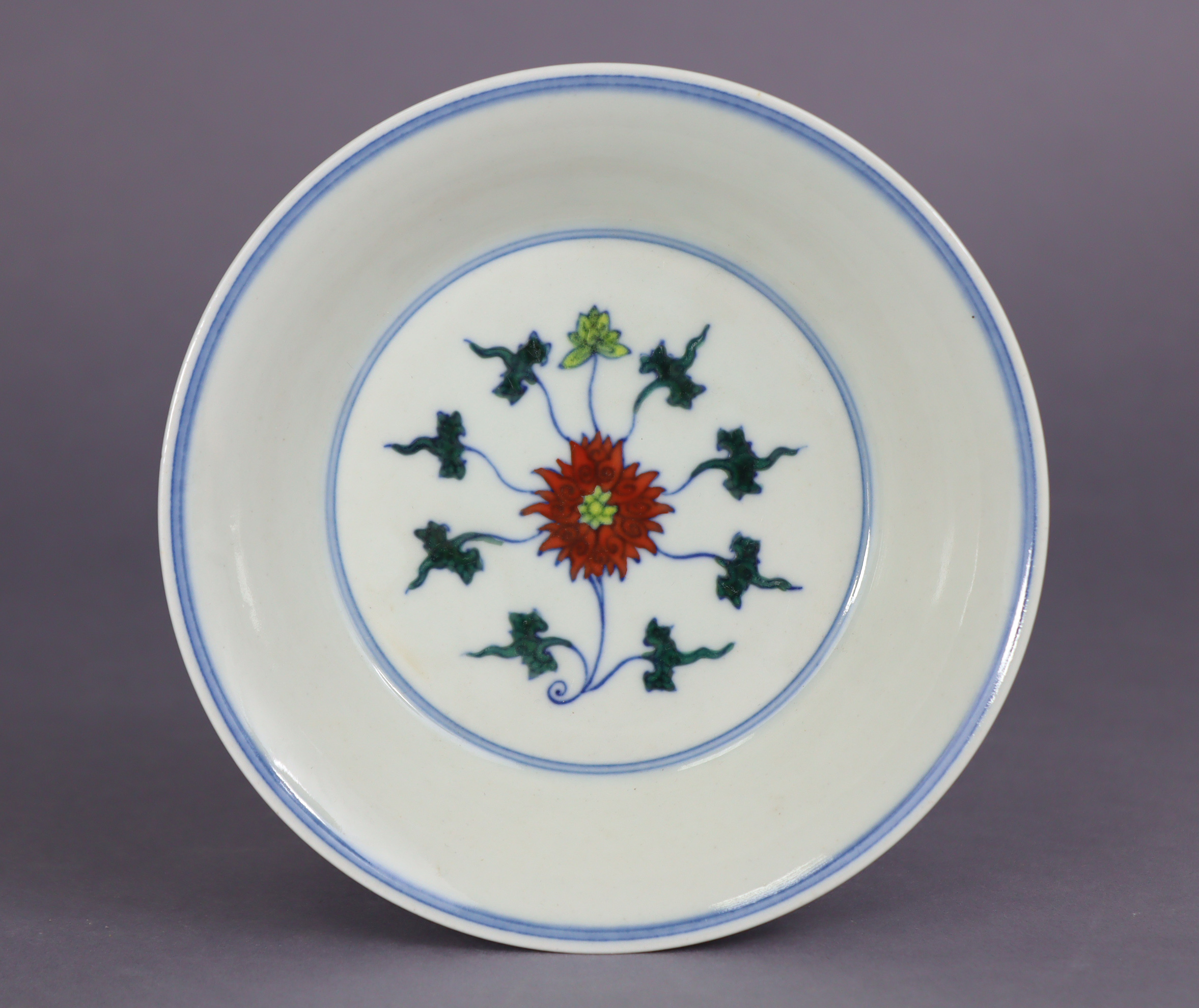 A Chinese porcelain dish with wide flared rim, decorated in underglaze blue & Doucai enamels with