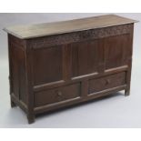 A late 17th/early 18th century joined oak coffer, with carved frieze & three-panel front above two