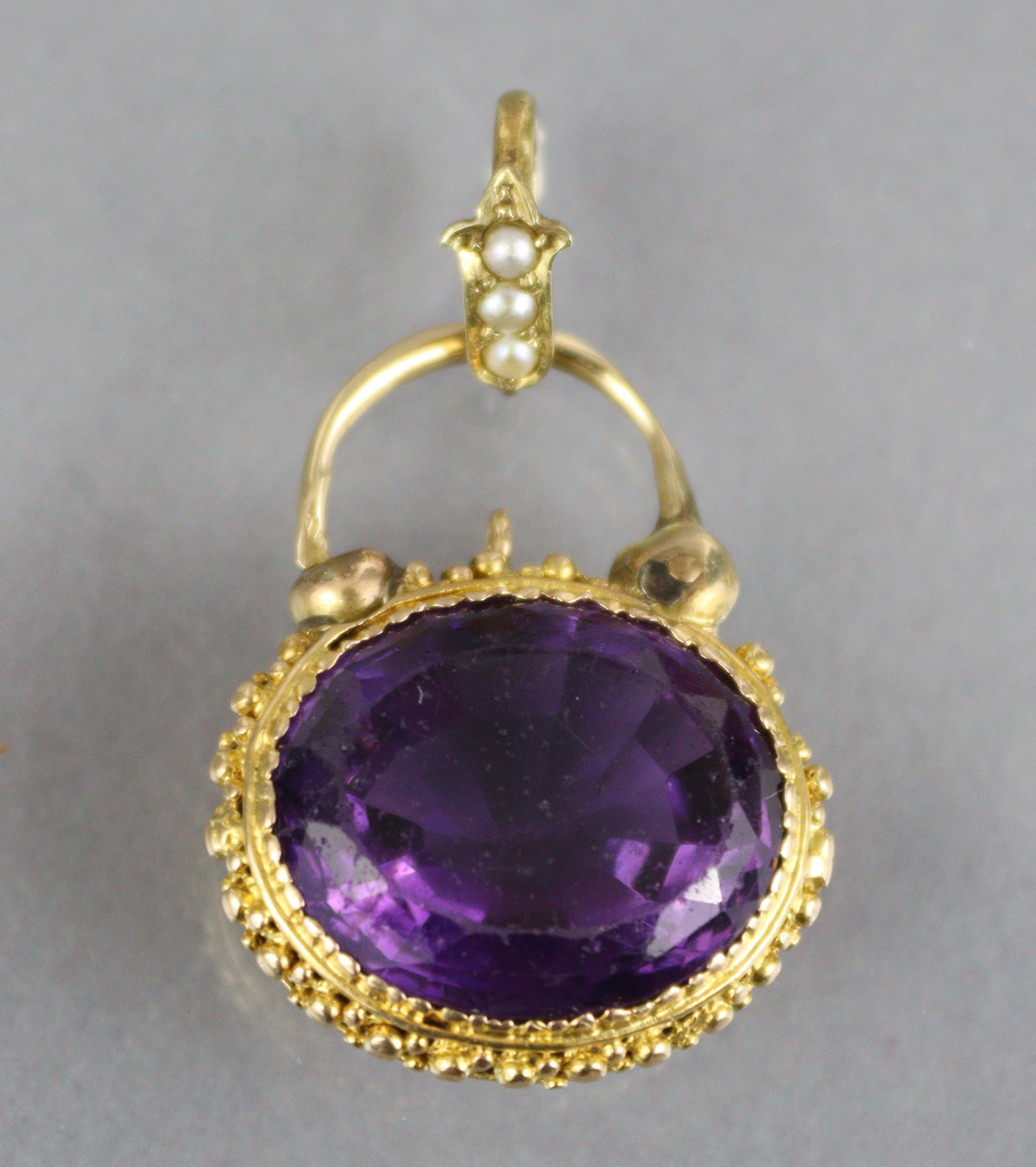 A Victorian amethyst pendant, the oval stone measuring approx. 18mm x 15mm x 9mm, set within a