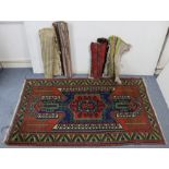 A Persian pattern rug of crimson & blue ground & with geometric design to centre within a wide