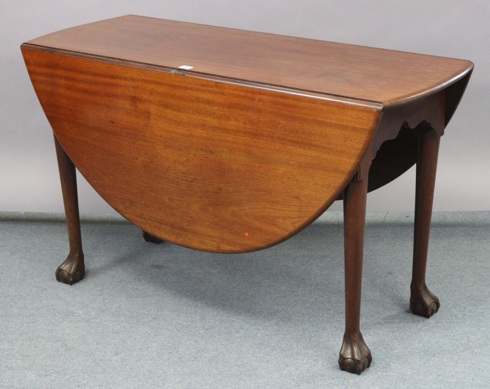 A late 19th century mahogany drop-leaf dining table, with oval top & on four round tapered legs with