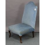 A matching nursing chair, on short cabriole legs & pad feet with ceramic castors.