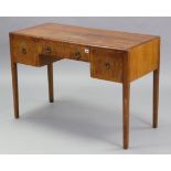 A 1960’s walnut kneehole dressing table fitted three frieze drawers, & on square tapered legs,